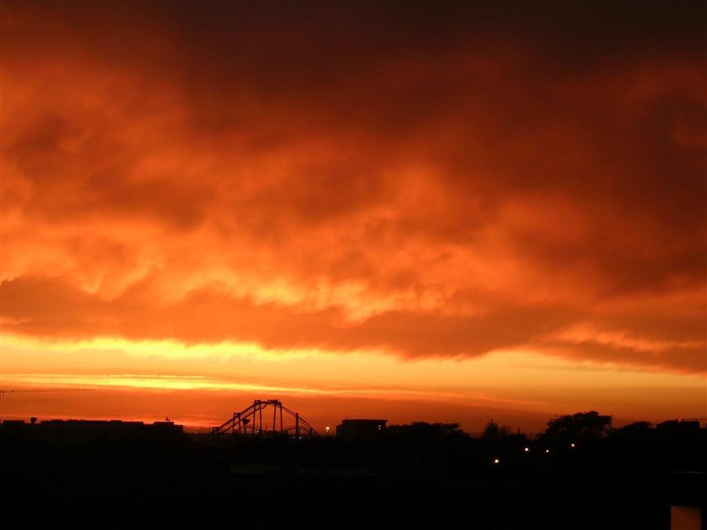 Cielo naranja de atardecer sobre un horizonte en sombra